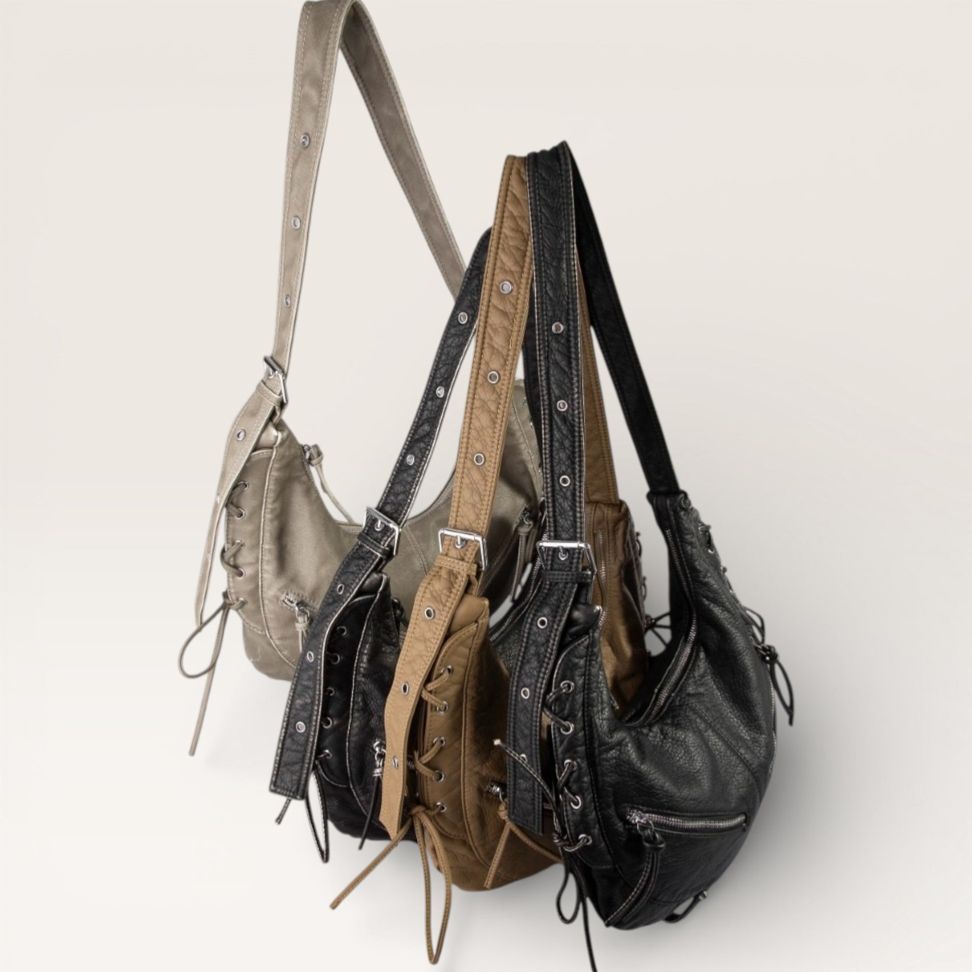 Three leather handbags in different colors on a light background