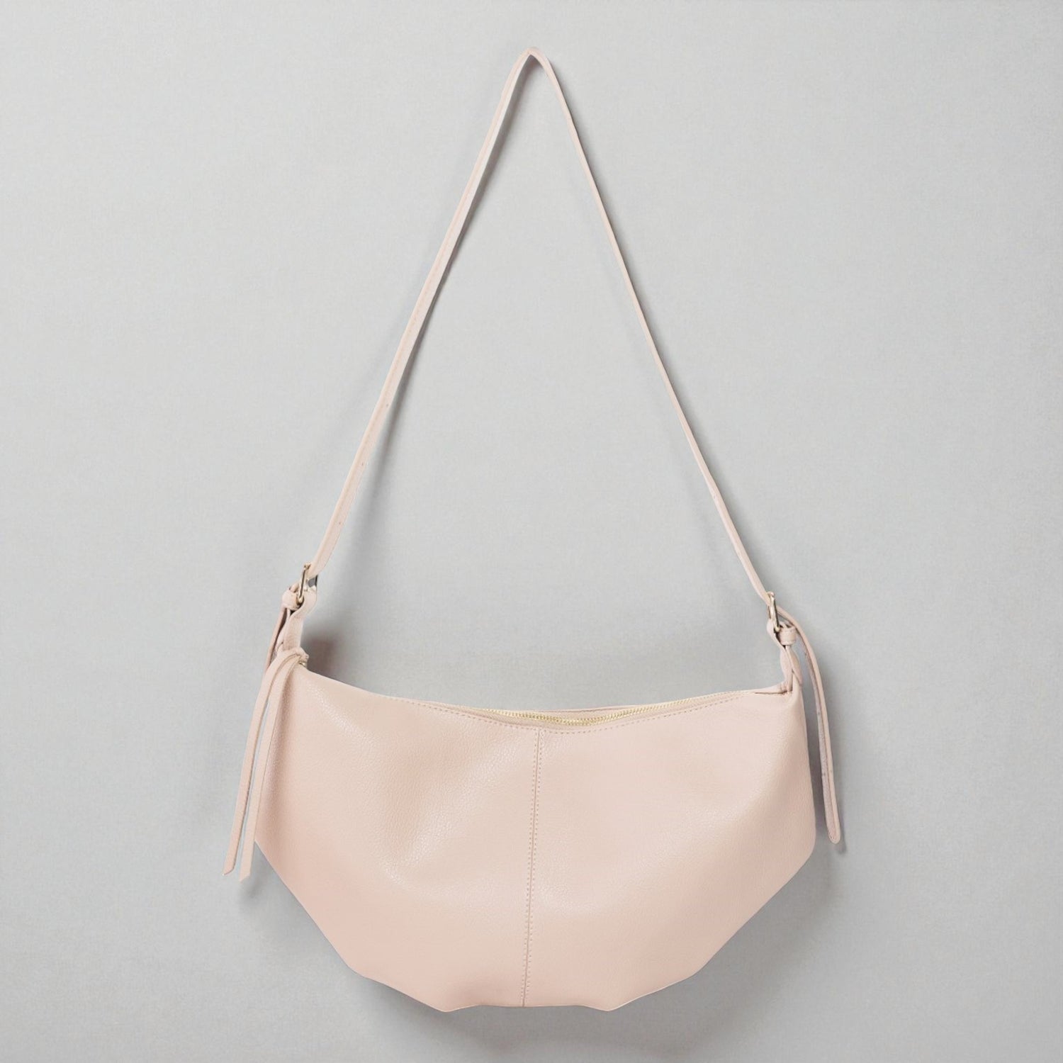 Pink handbag with a strap on a gray background