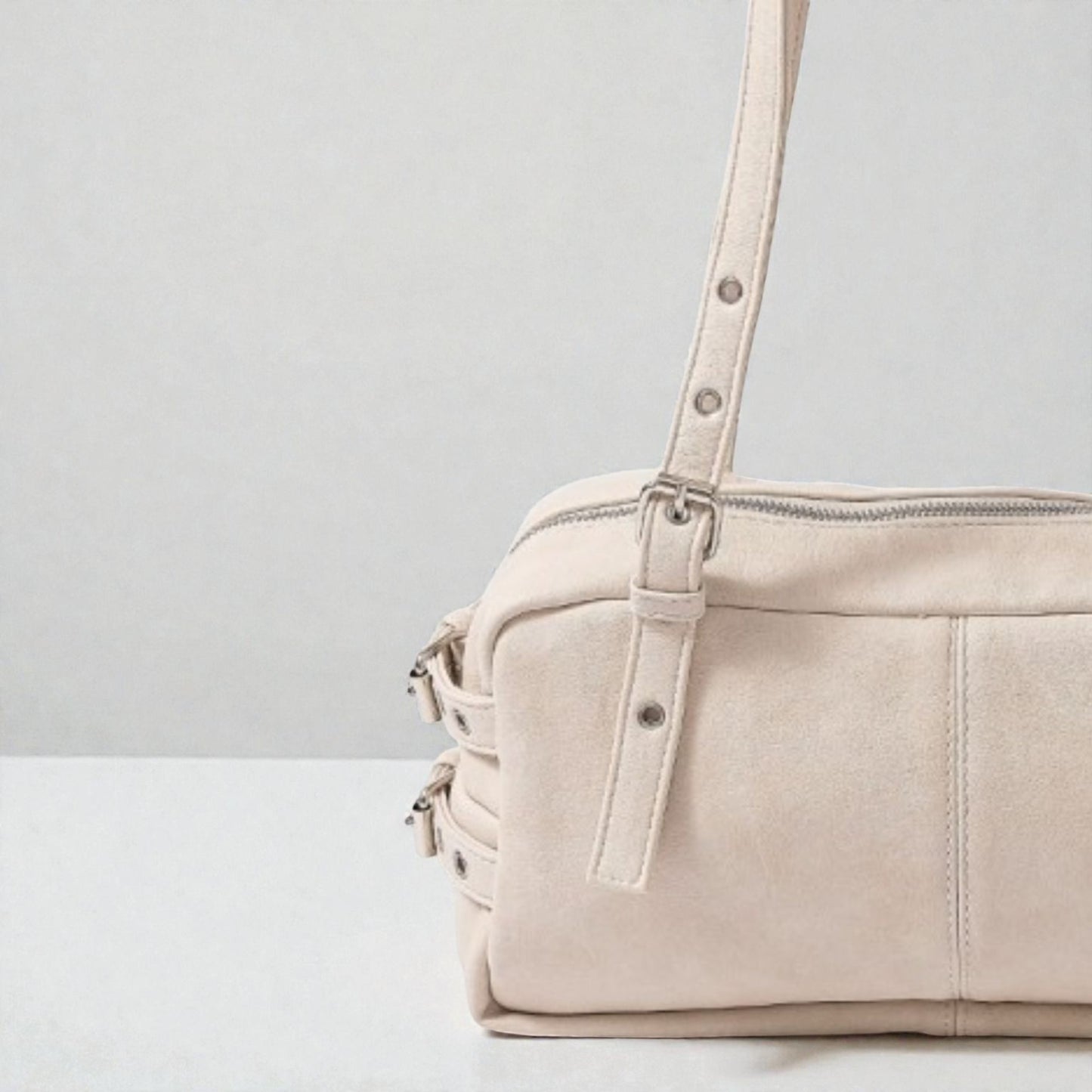 Beige handbag with a strap on a light gray background