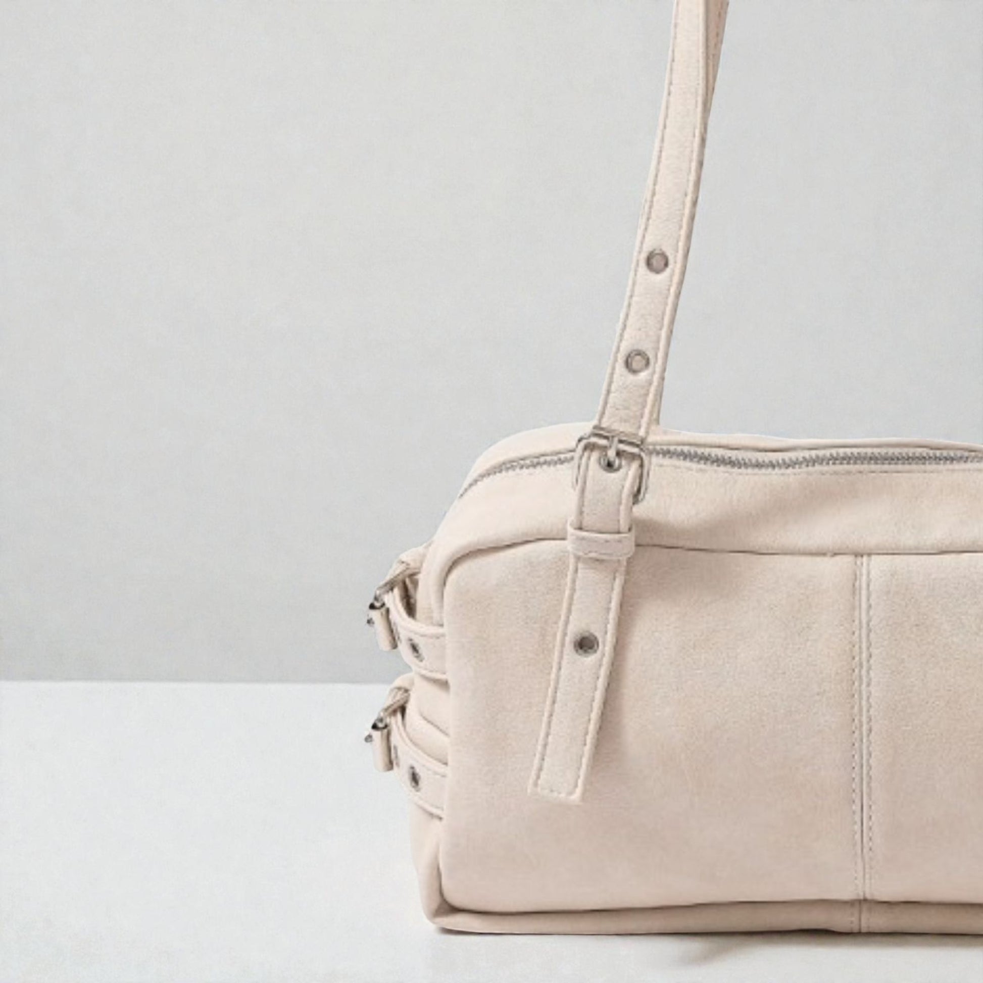 Beige handbag with a strap on a light gray background
