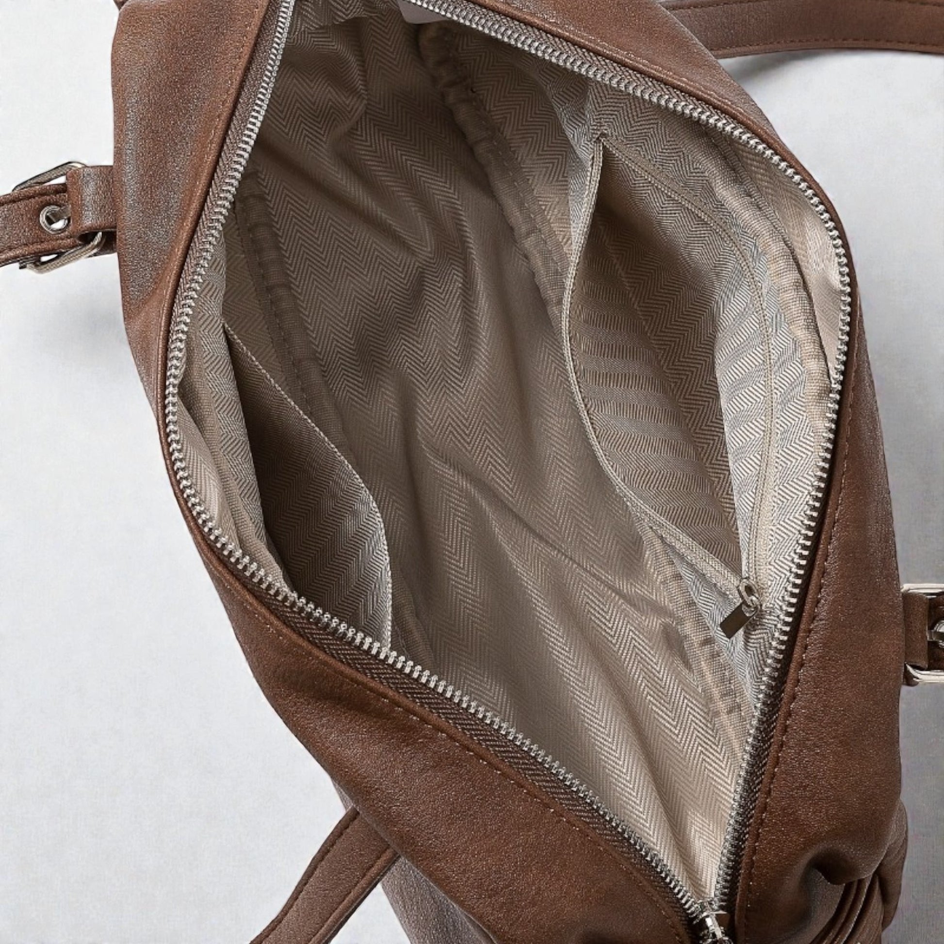 Brown leather bag with open zipper on a white background