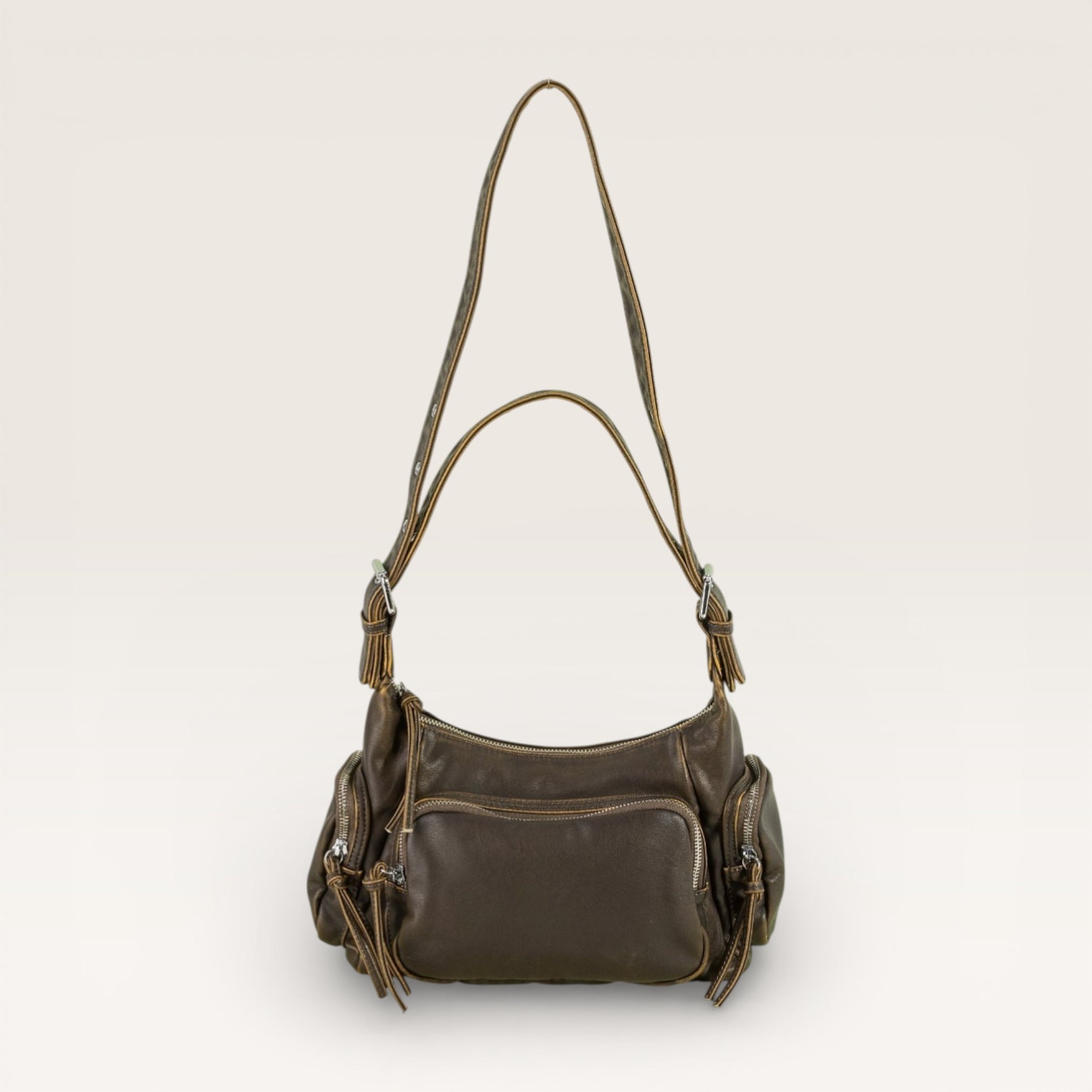 Brown leather handbag with a shoulder strap on a light beige background