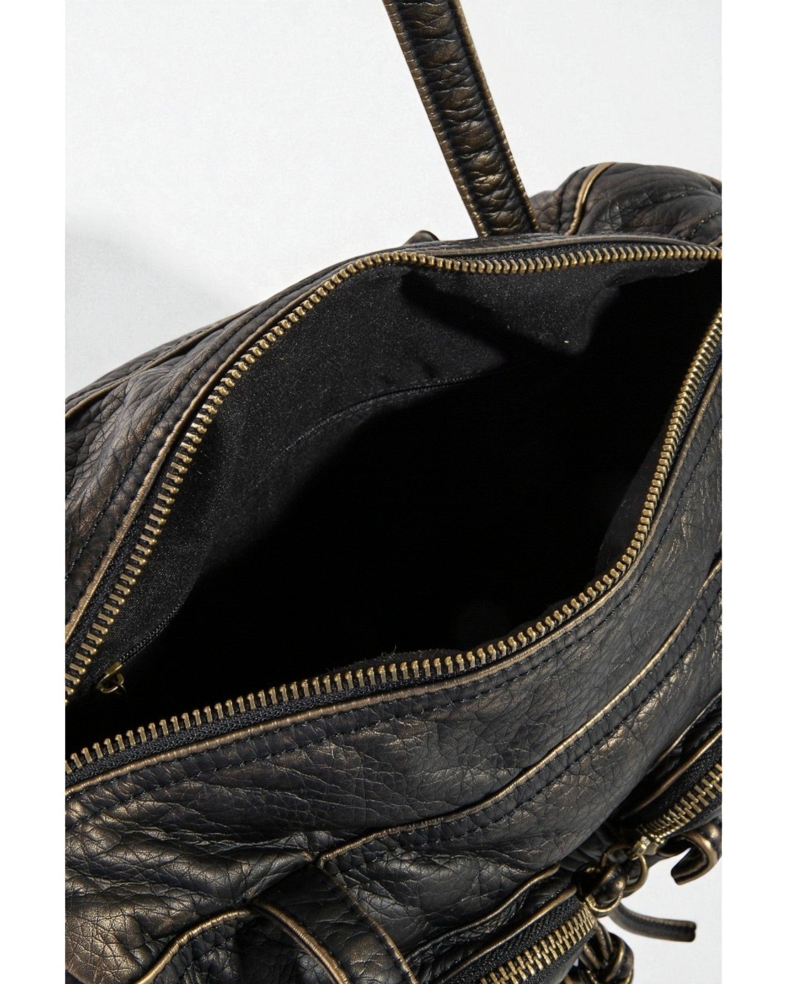 Close-up of a black leather bag with gold zipper details on a white background