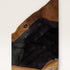 Close-up of a brown leather bag with black interior lining on a light gray background