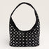 Black handbag with silver studs on a light gray background