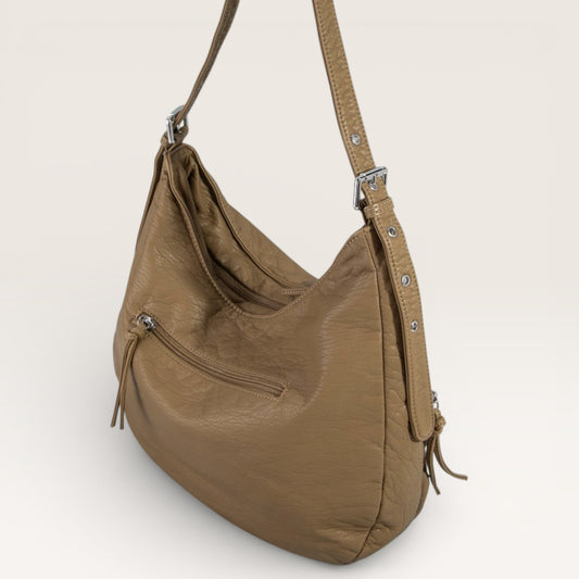 Brown leather handbag with a shoulder strap on a light beige background
