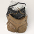 Brown leather handbag with multiple zippers on a white background