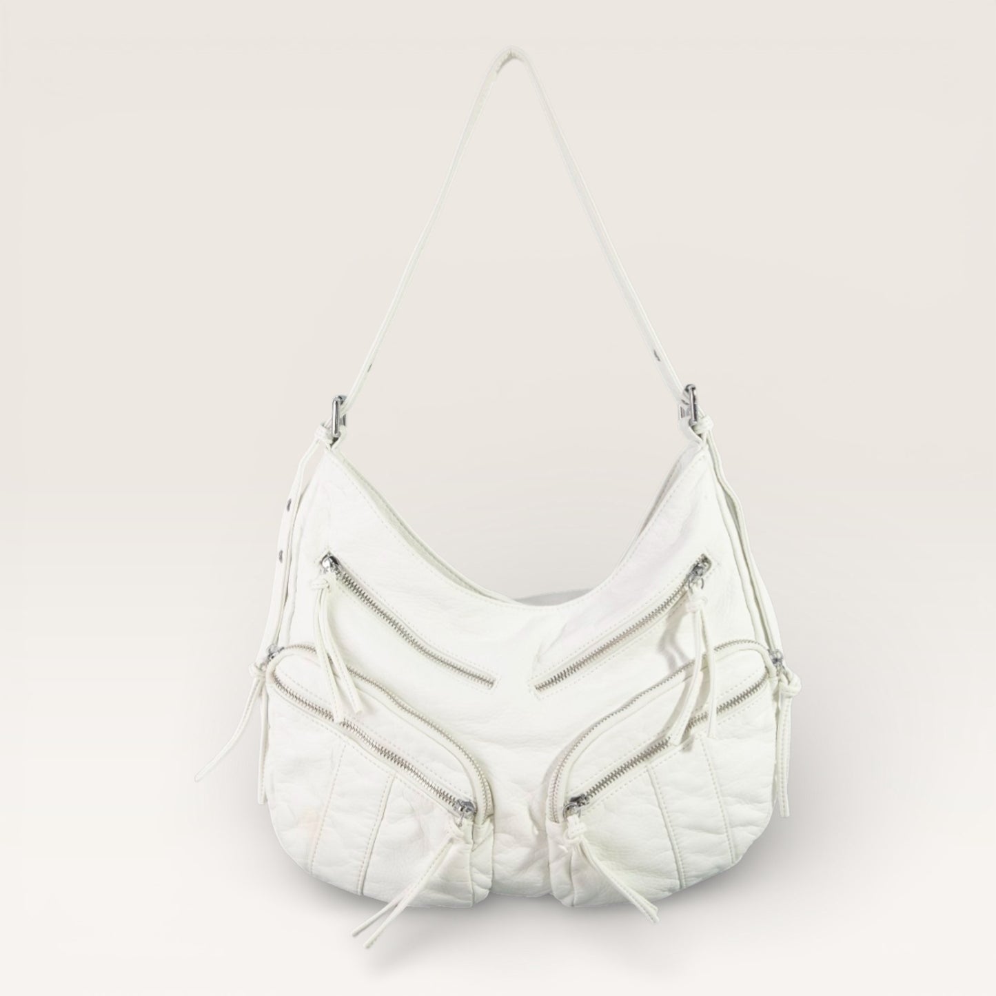 White handbag with zippers on a light gray background