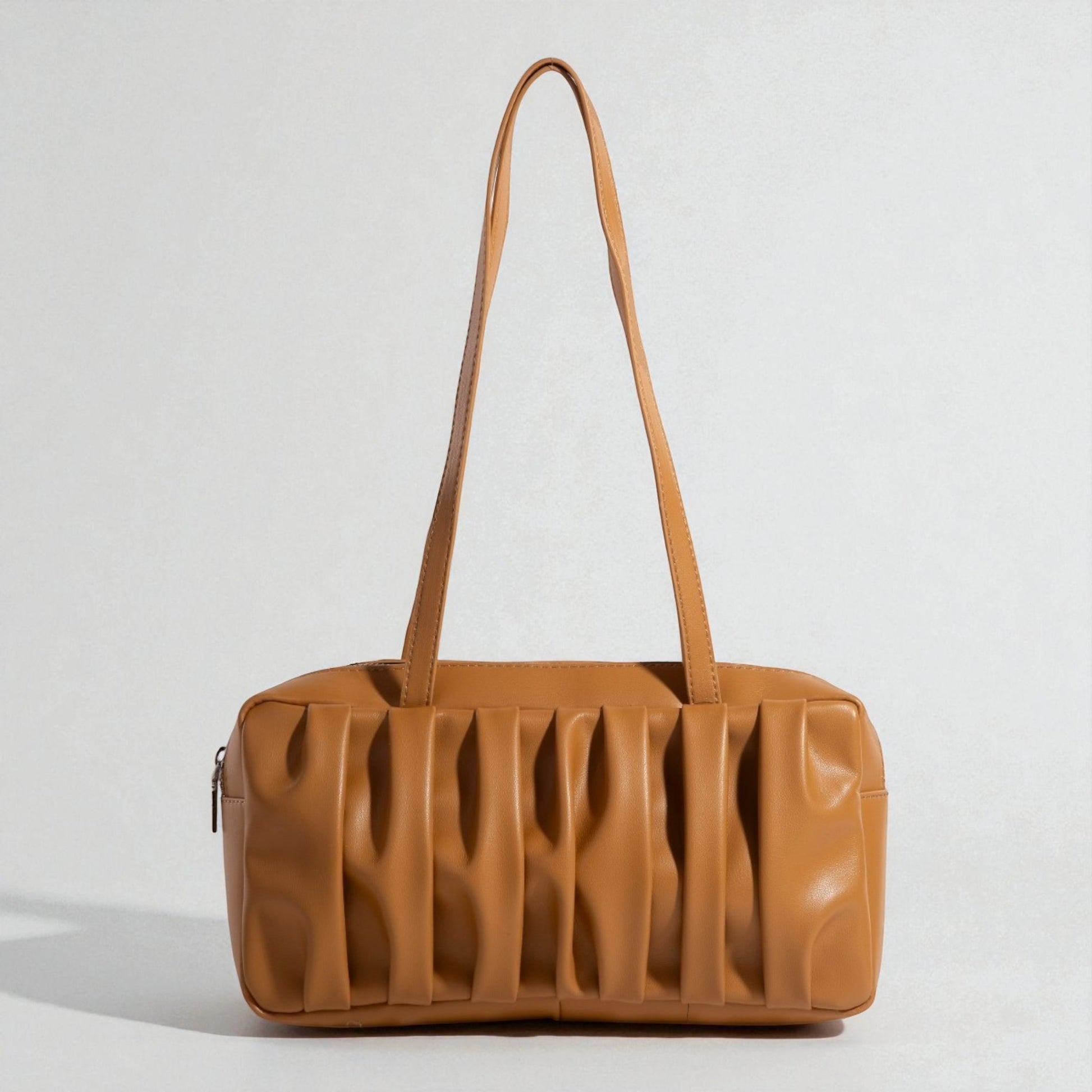 Brown leather handbag with a textured surface on a light gray background