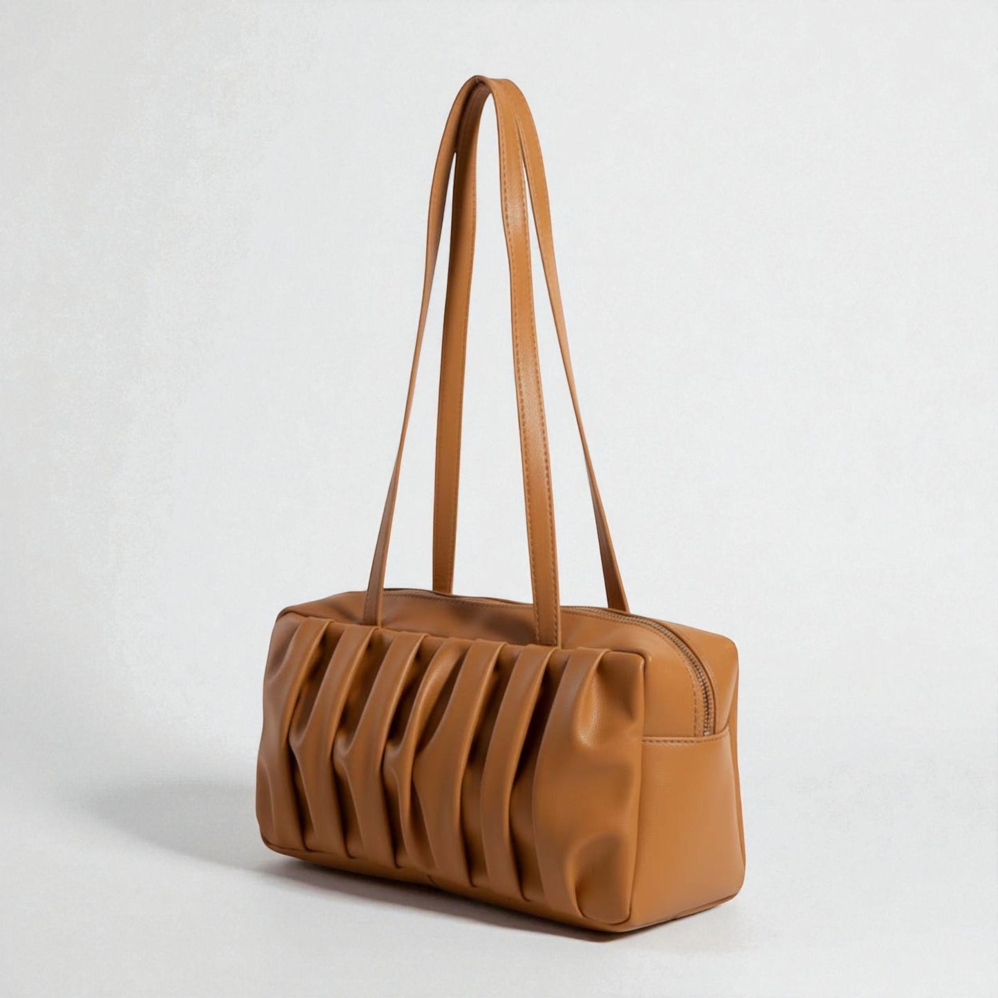 Brown leather handbag with a unique design on a light gray background