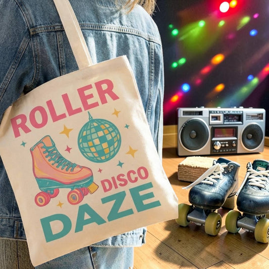 Person holding a tote bag with 'Roller Disco Daze' design, next to roller skates and a boombox.