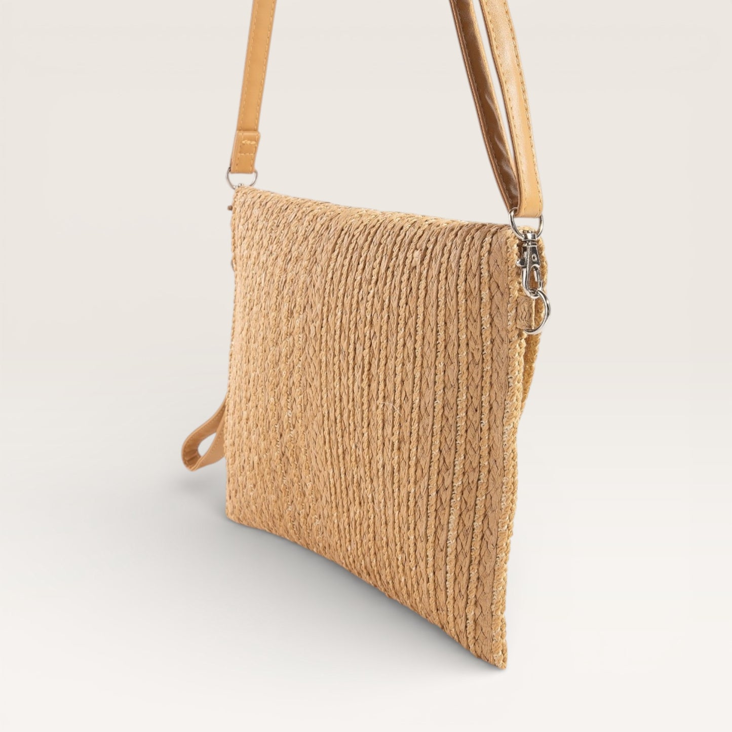 Beige straw handbag with a strap on a light gray background