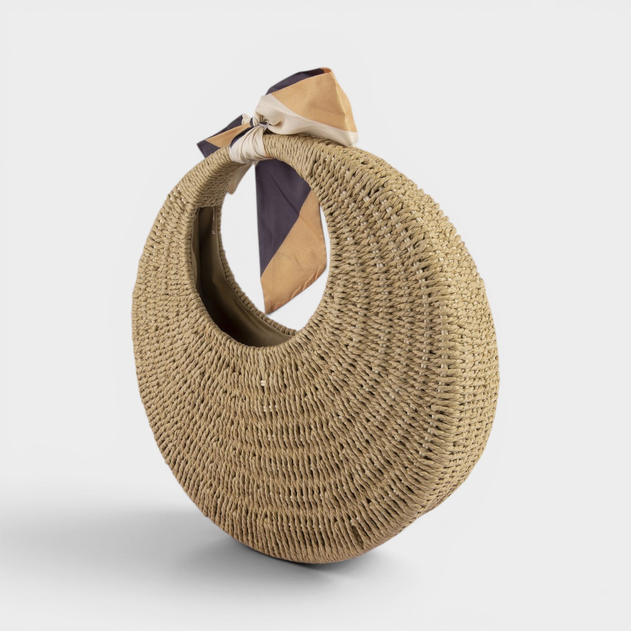 Round straw handbag with a strap on a light gray background