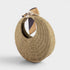 Round straw handbag with a strap on a light gray background