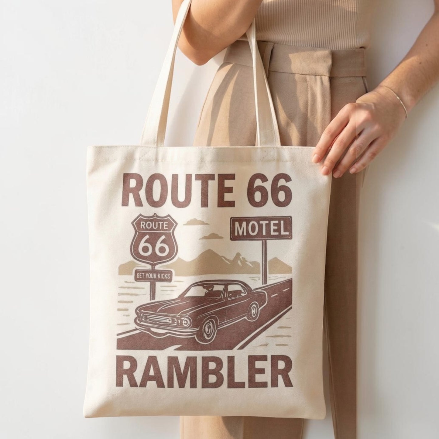 Tote bag with Route 66 and Rambler design held by a person against a white background