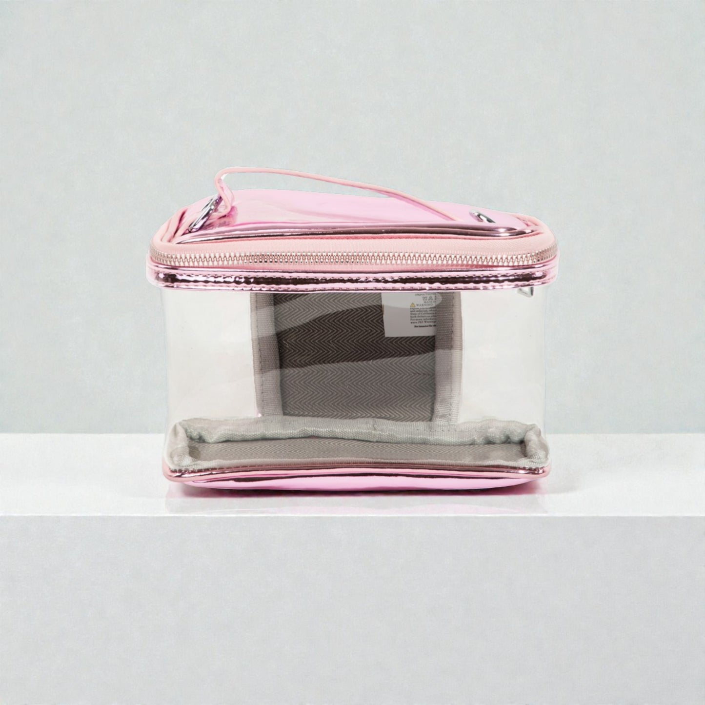 Clear cosmetic bag with pink zipper on a white background