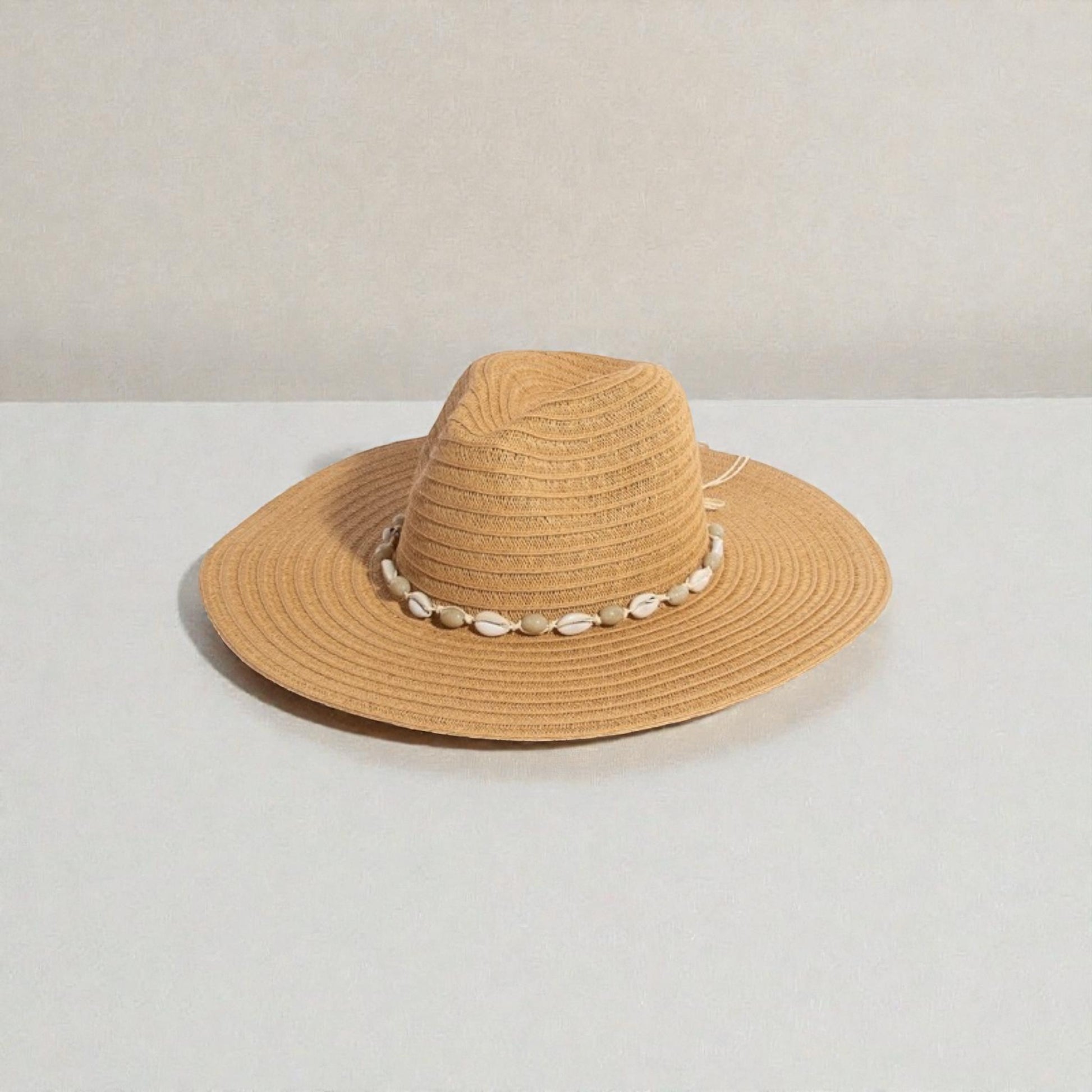 Beige straw hat with a decorative band on a white background
