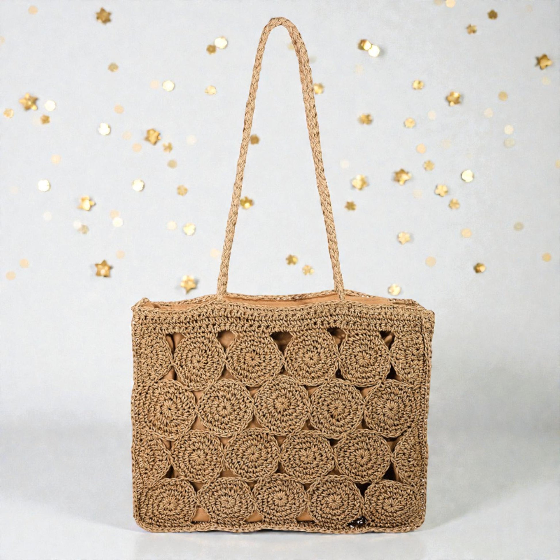 Woven handbag with a textured pattern on a light gray background with gold confetti.