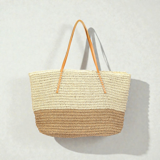 Woven straw tote bag with leather handles on a light gray background