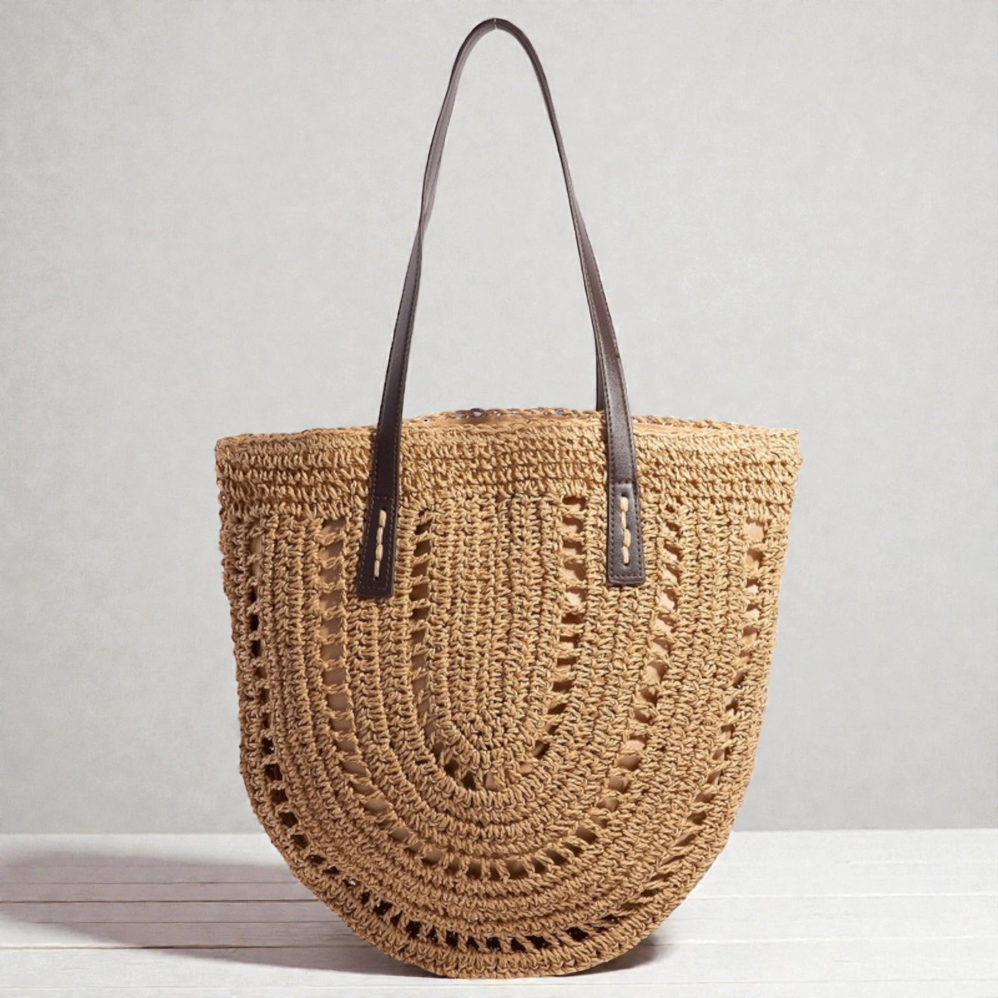 Woven handbag with leather straps on a light gray background