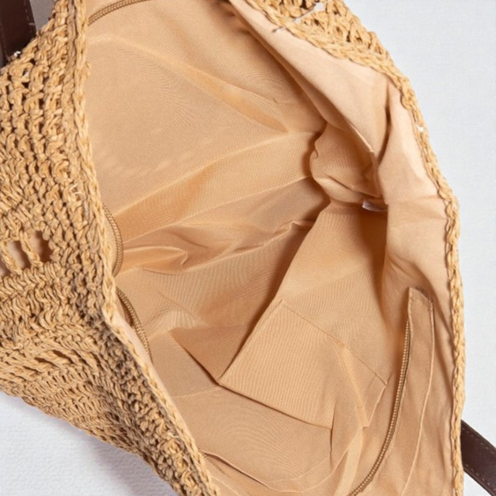 Close-up of a beige handbag with a textured woven handle.