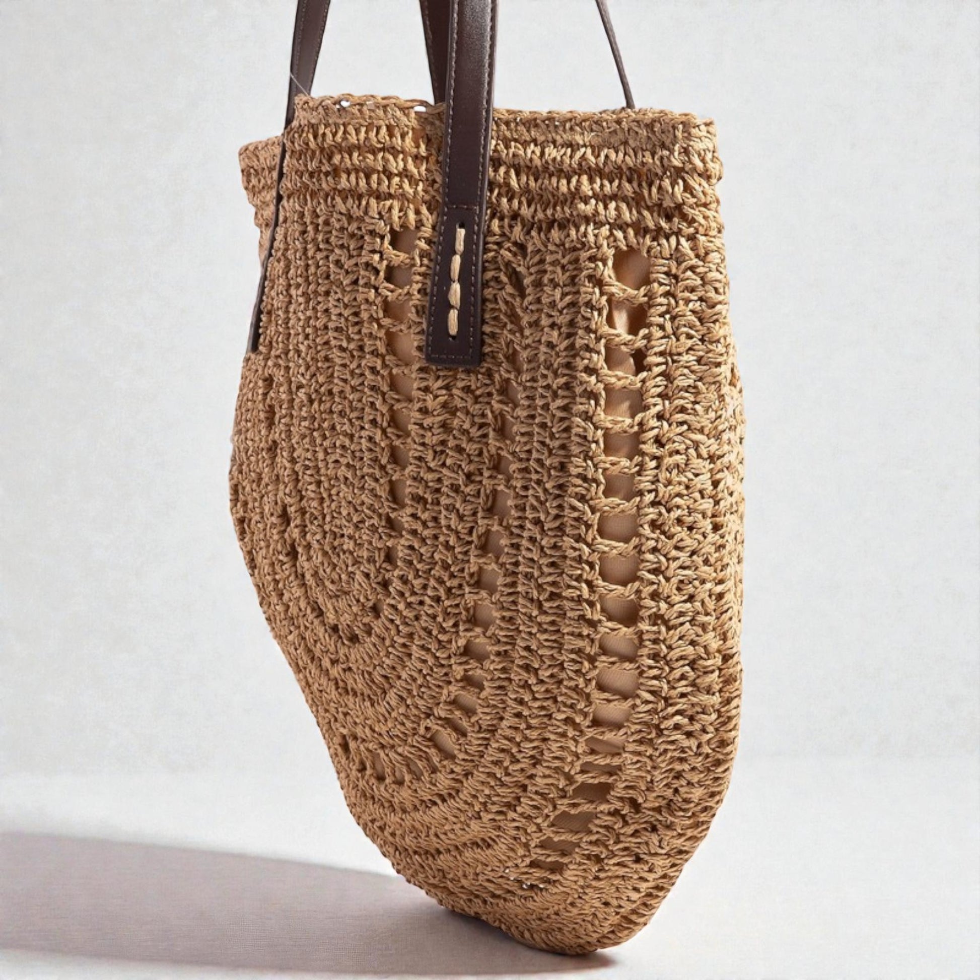 Brown woven handbag with leather handle on a light gray background