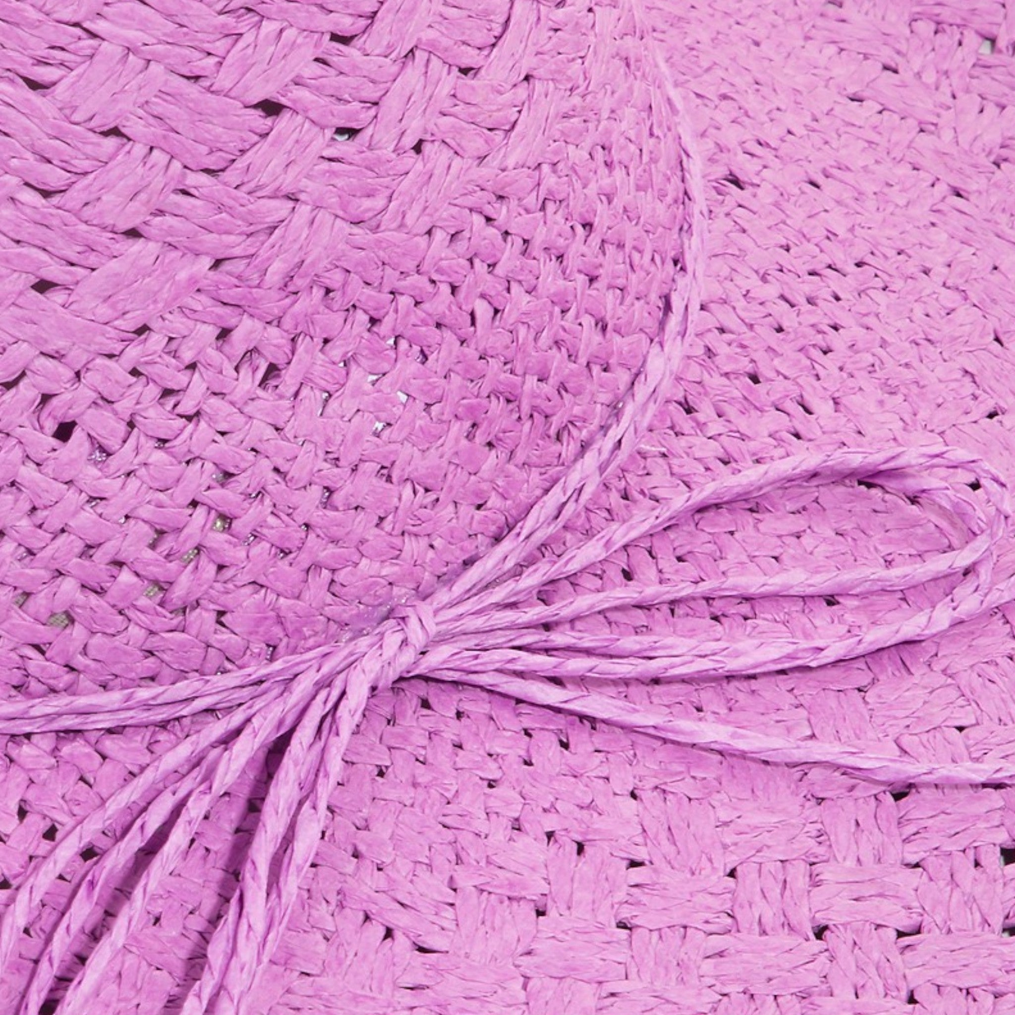 Close-up of pink yarn on a textured pink fabric background