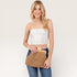Woman holding a cork clutch bag against a plain background