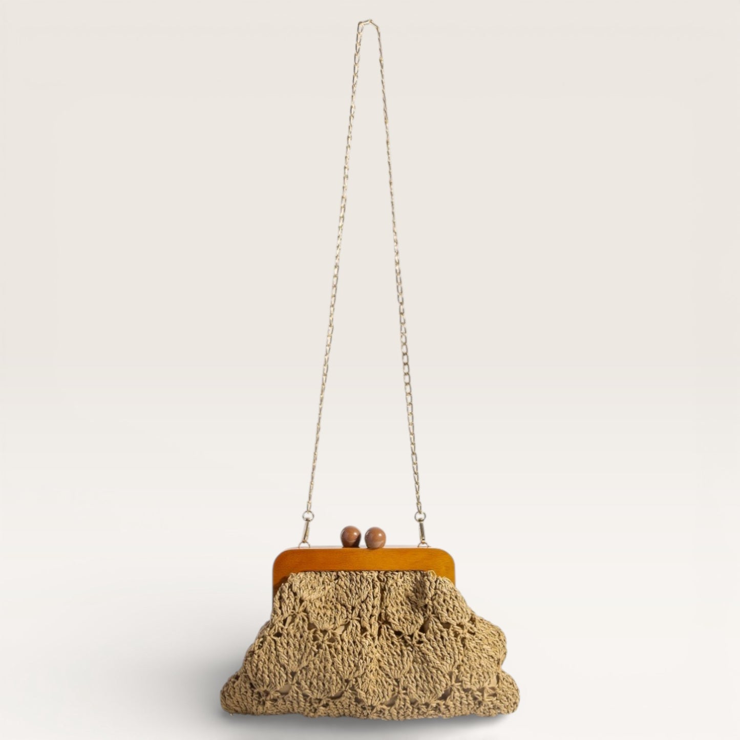 Crocheted handbag with wooden frame on a light gray background