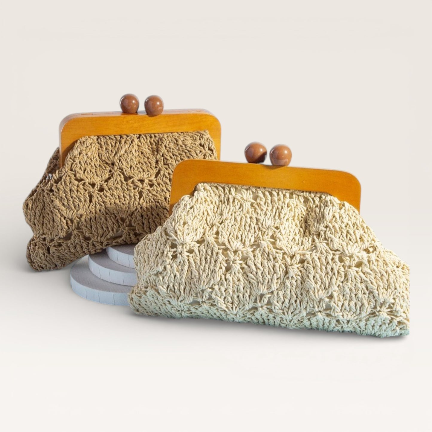 Two knitted pouches with wooden clasps on a light background