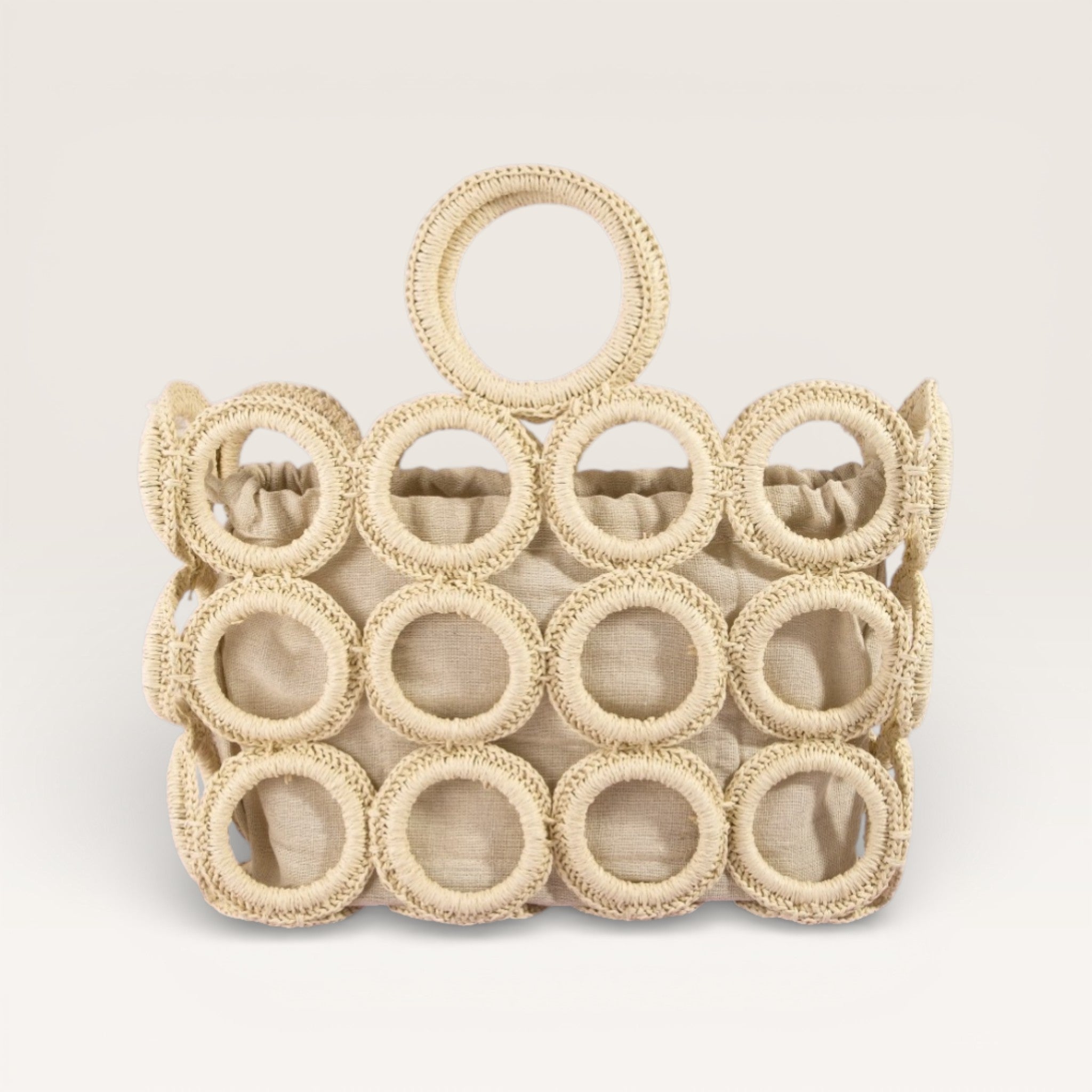 Beige woven handbag with circular design on a light beige background