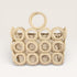 Beige woven handbag with circular design on a light beige background