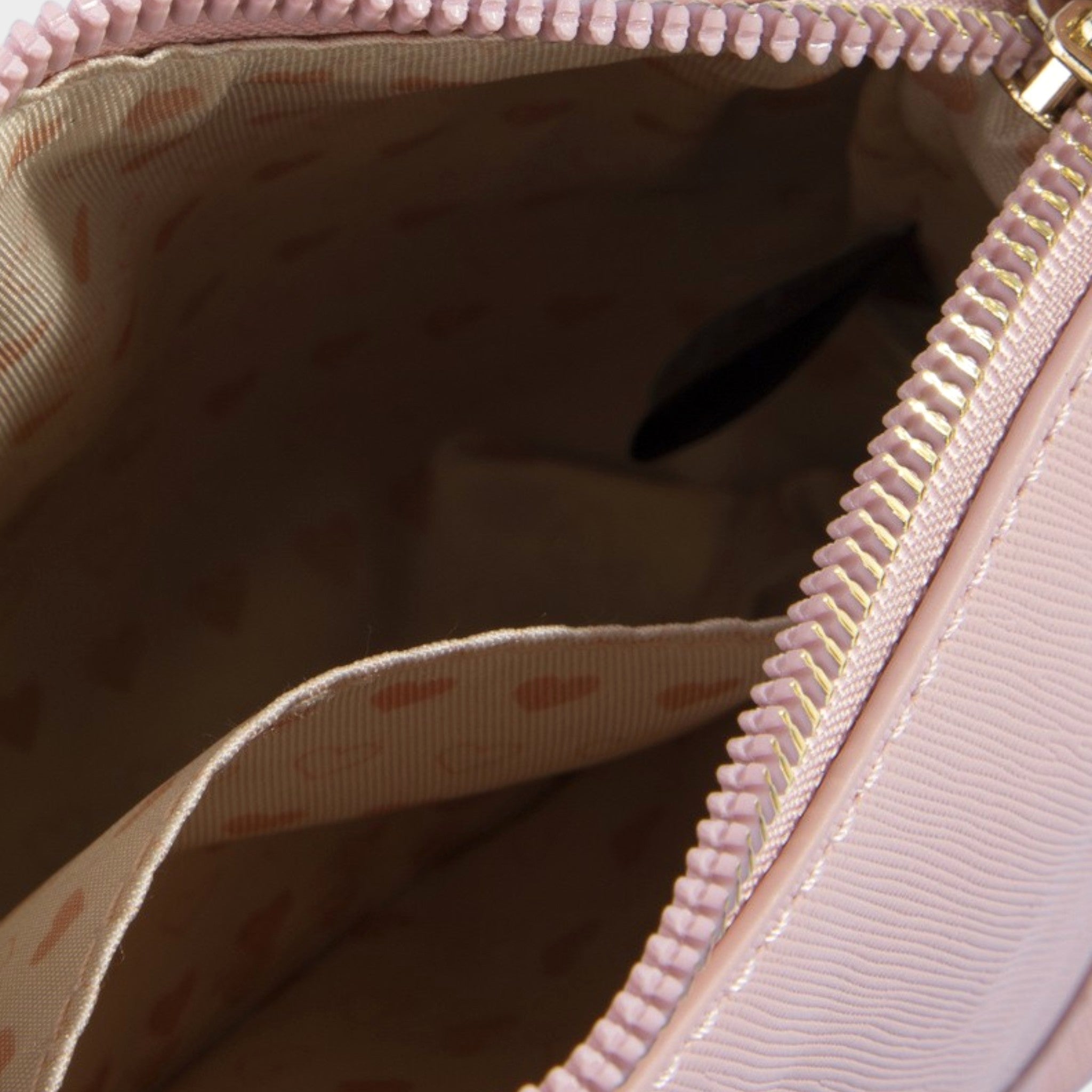 Close-up of a pink handbag with a zipper, showing the interior.