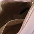 Close-up of a pink handbag with a zipper, showing the interior.
