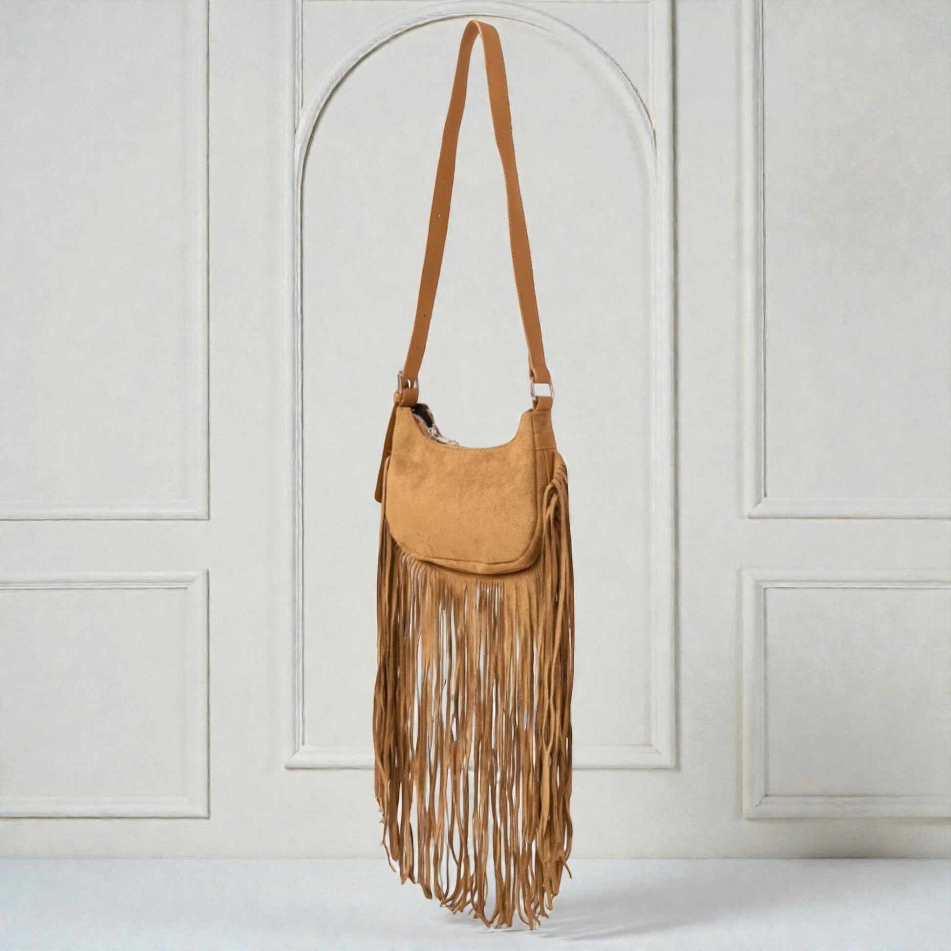 Brown suede handbag with fringe details on a white background