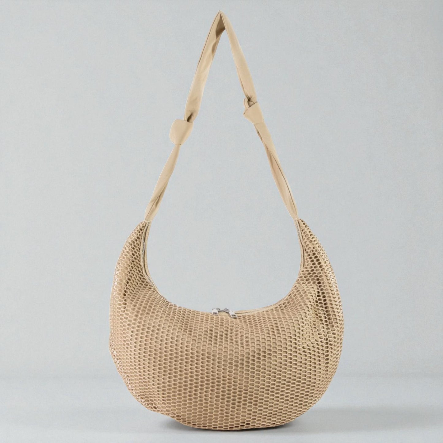 Beige woven handbag with a strap on a light gray background