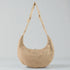Beige woven handbag with a strap on a light gray background
