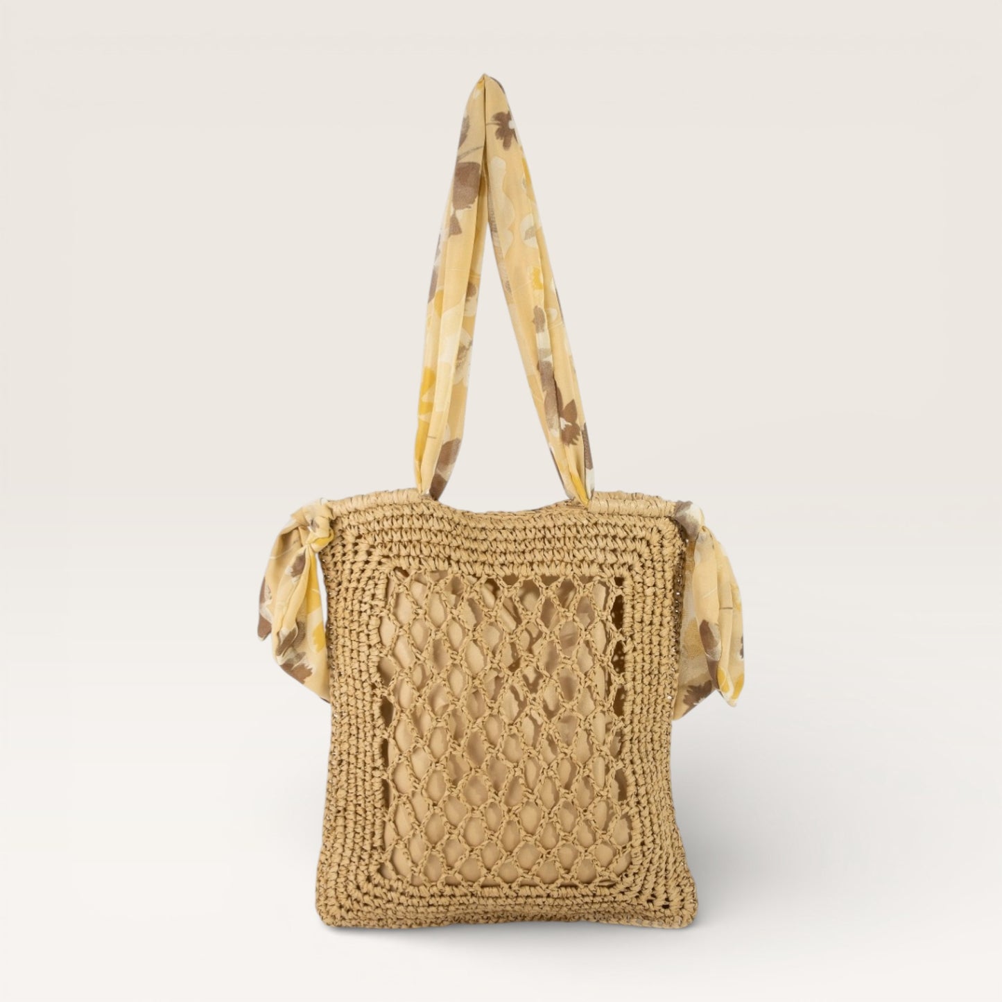 Beige woven handbag with a patterned strap on a light beige background