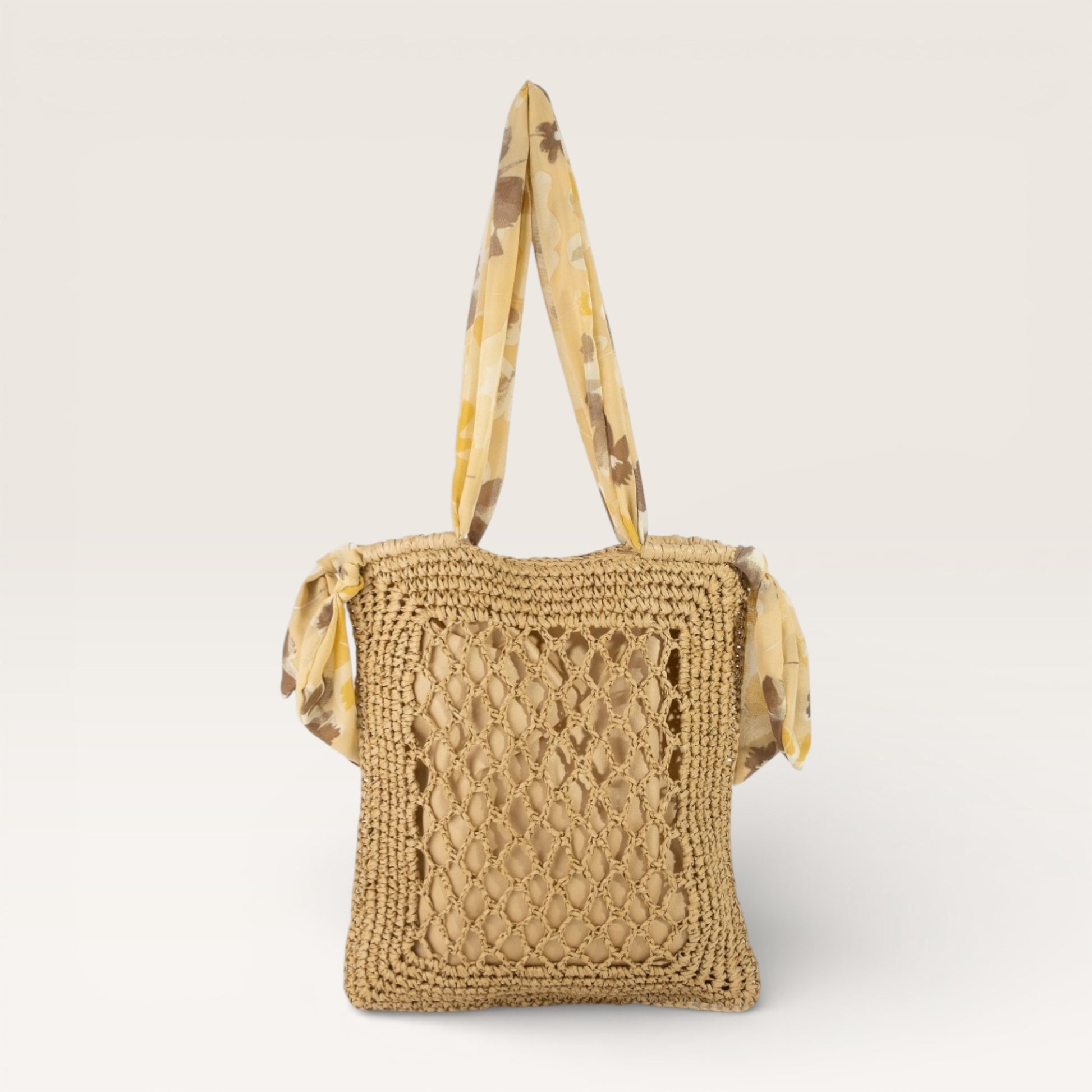 Beige woven handbag with a patterned strap on a light beige background