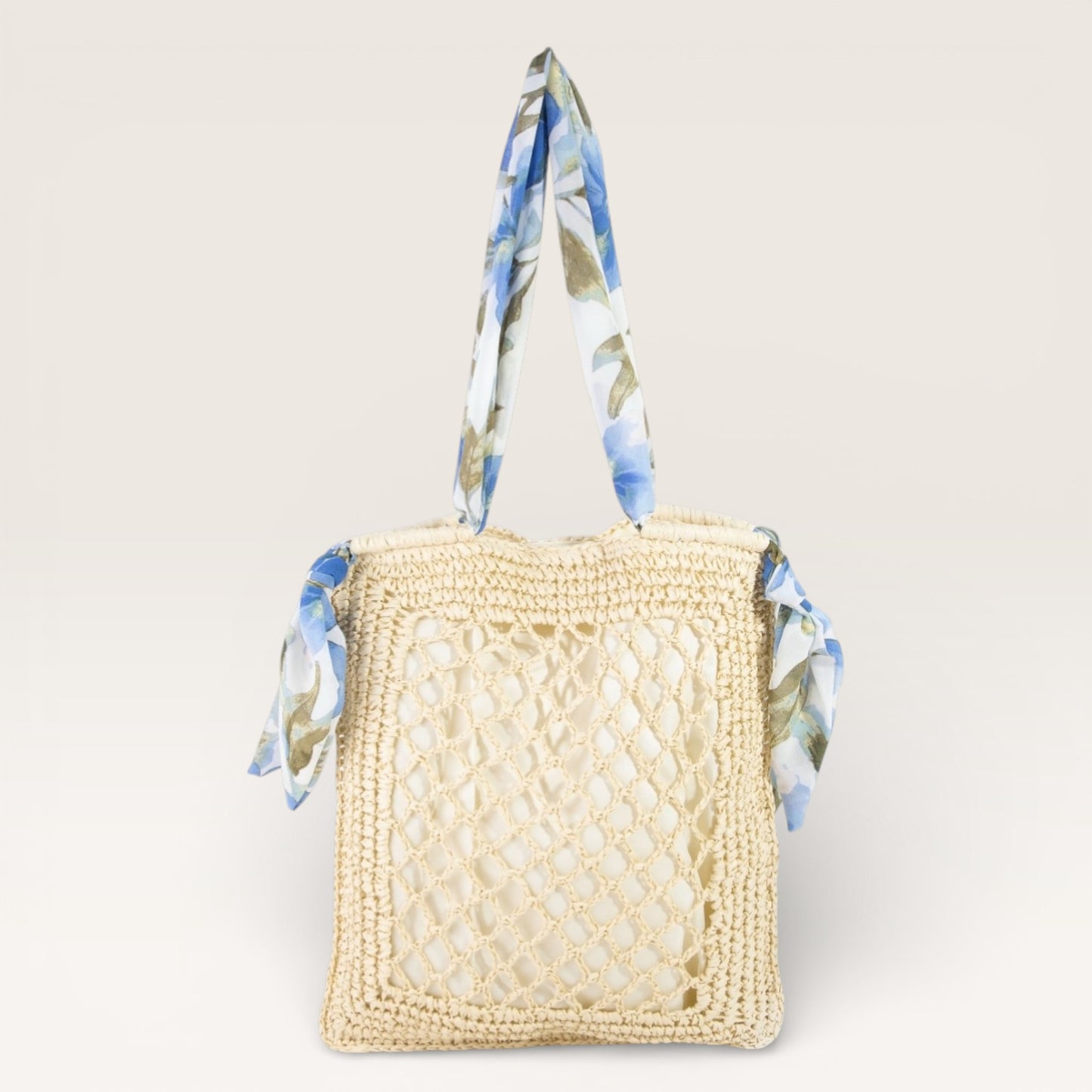 Woven handbag with floral handle on a light beige background