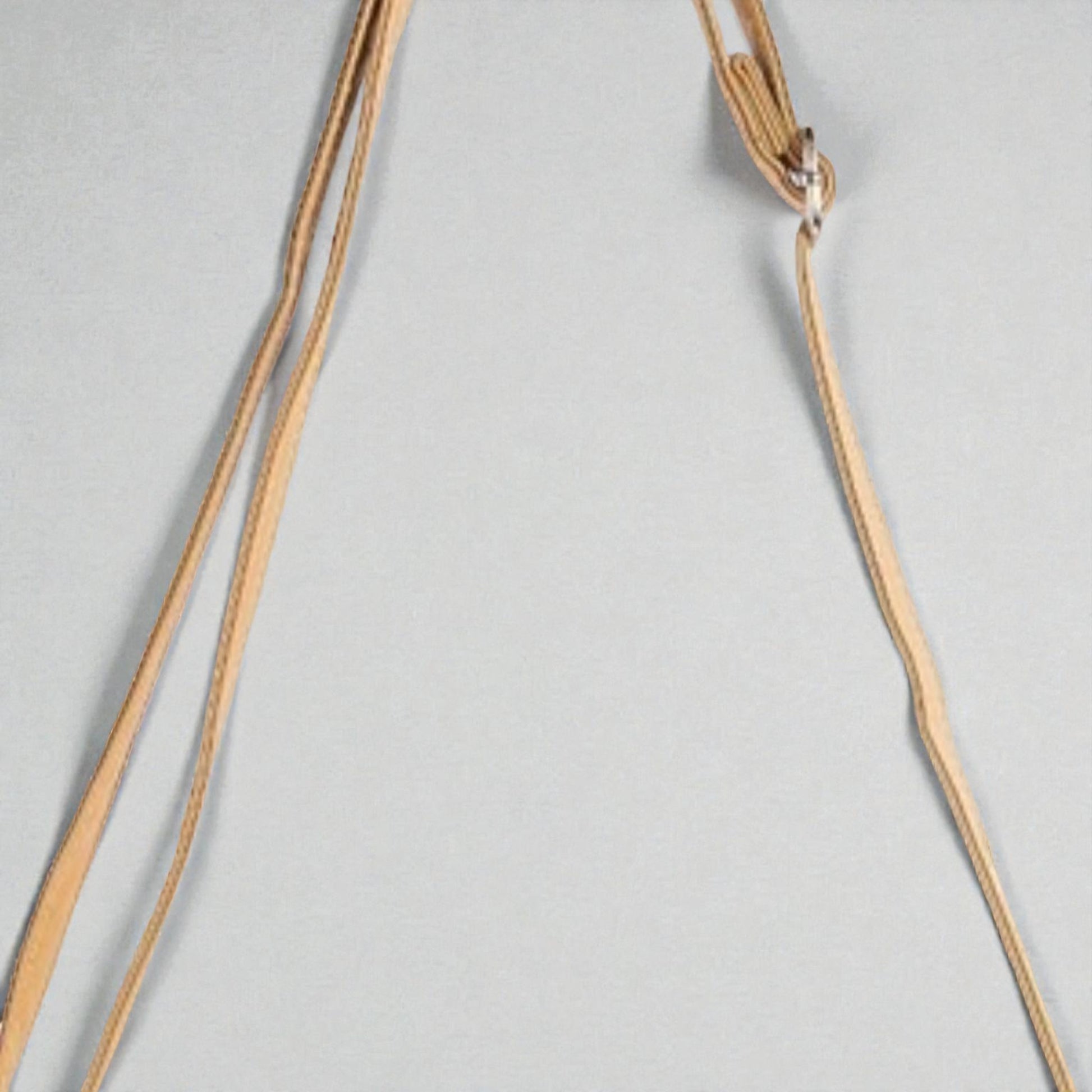 Gold necklace on a light gray background