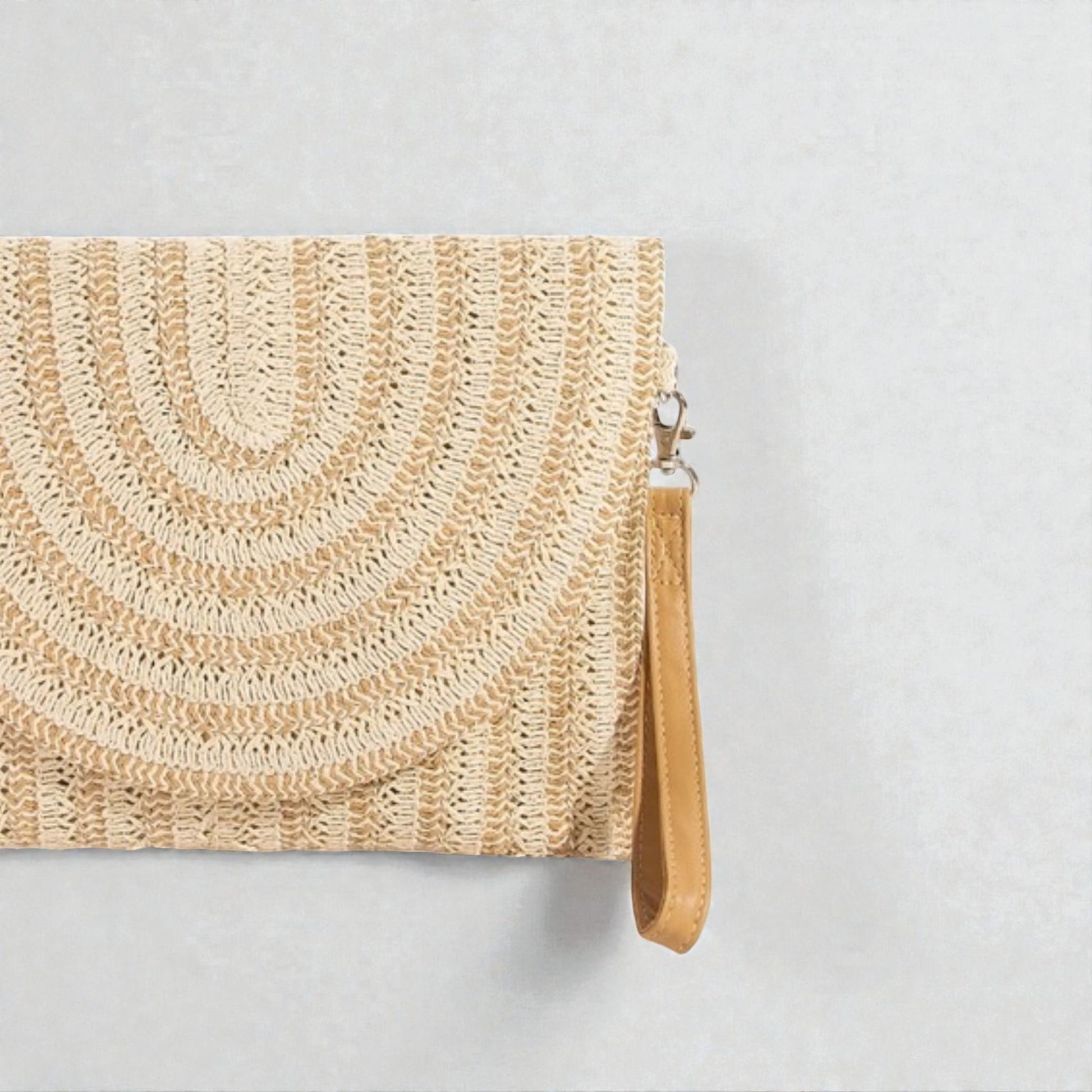Woven clutch bag with a strap on a light gray background