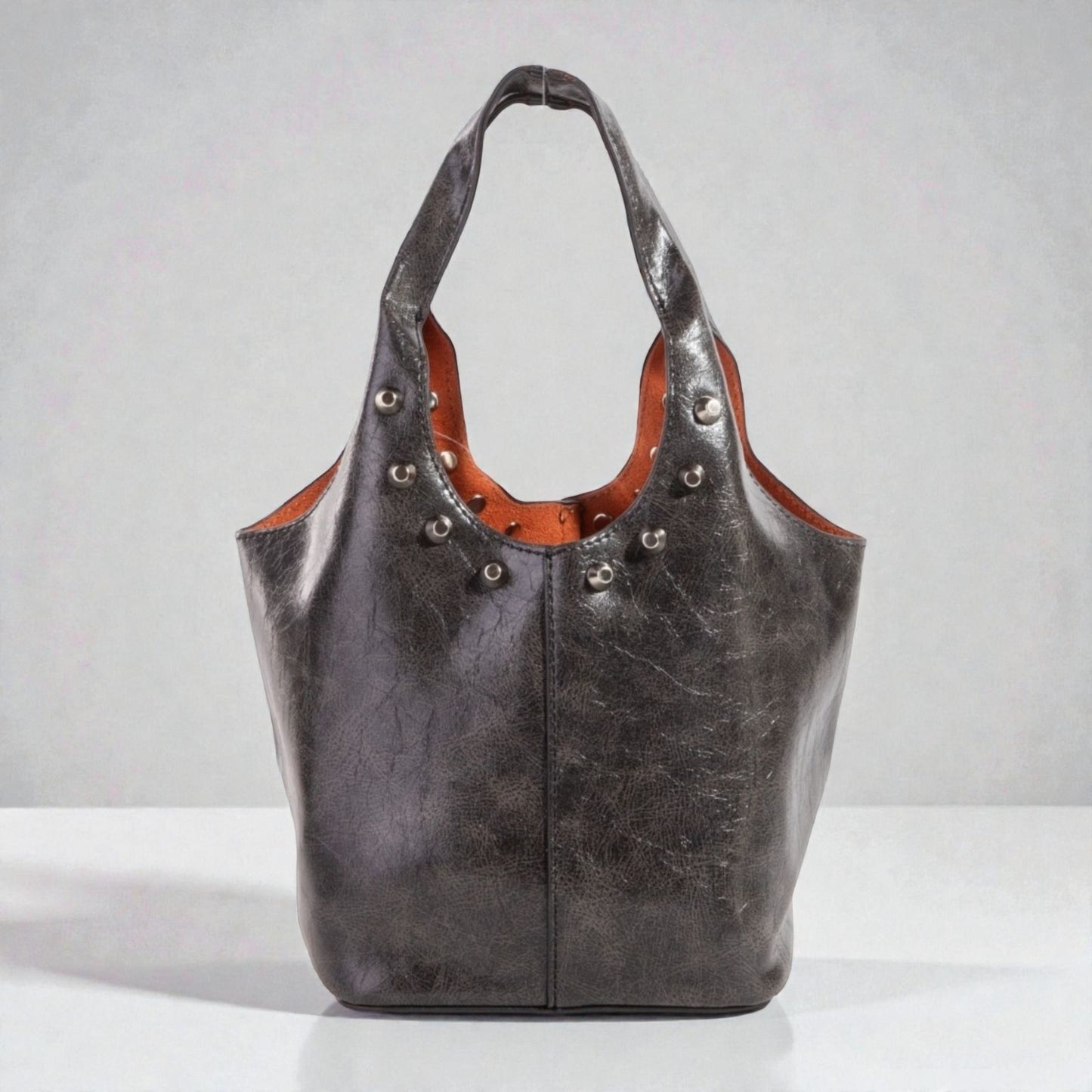 Black leather handbag with brown interior on a white background