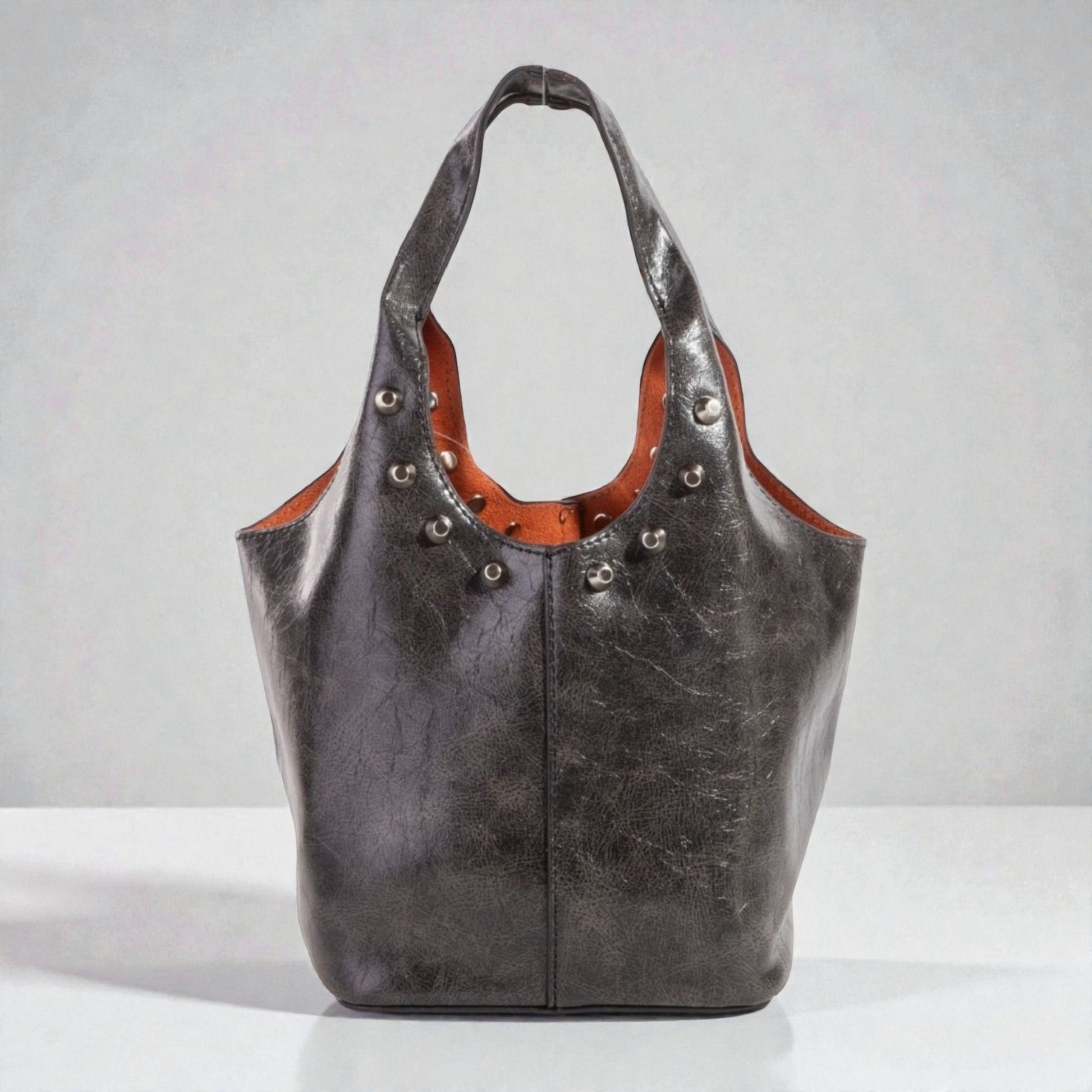 Black leather handbag with brown interior on a white background