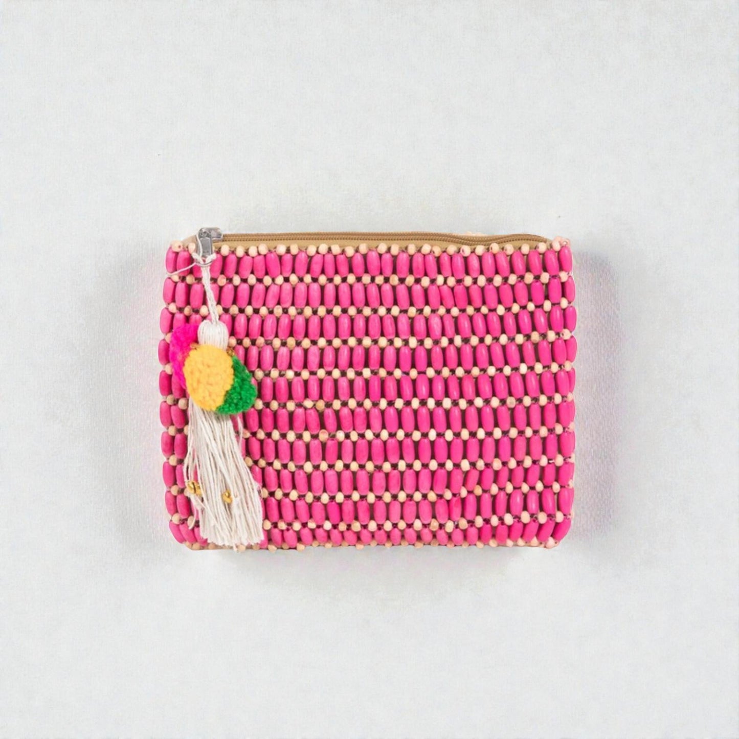 Pink beaded clutch with tassel on a light gray background