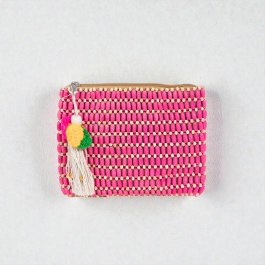 Pink beaded clutch with tassel on a light gray background