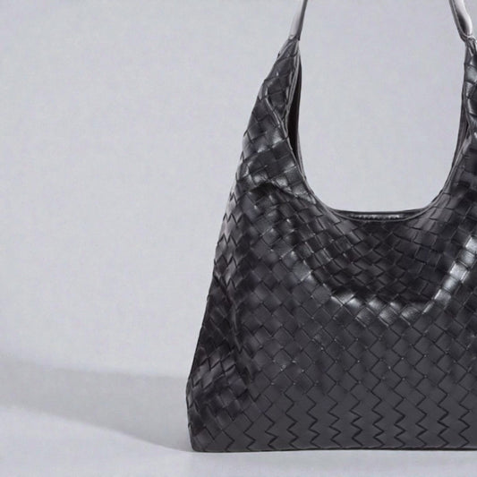 Black woven handbag on a light gray background