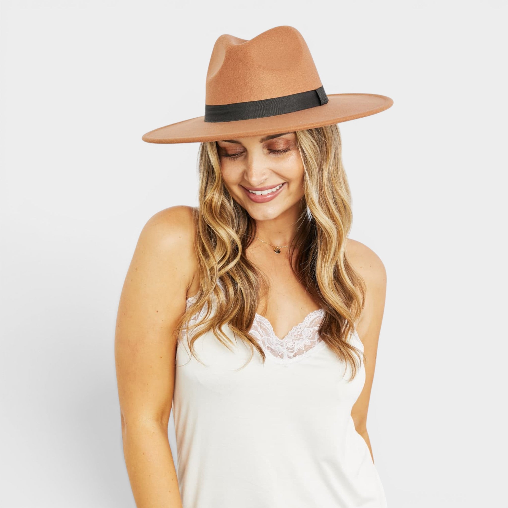 Woman wearing a brown hat with a black band on a white background