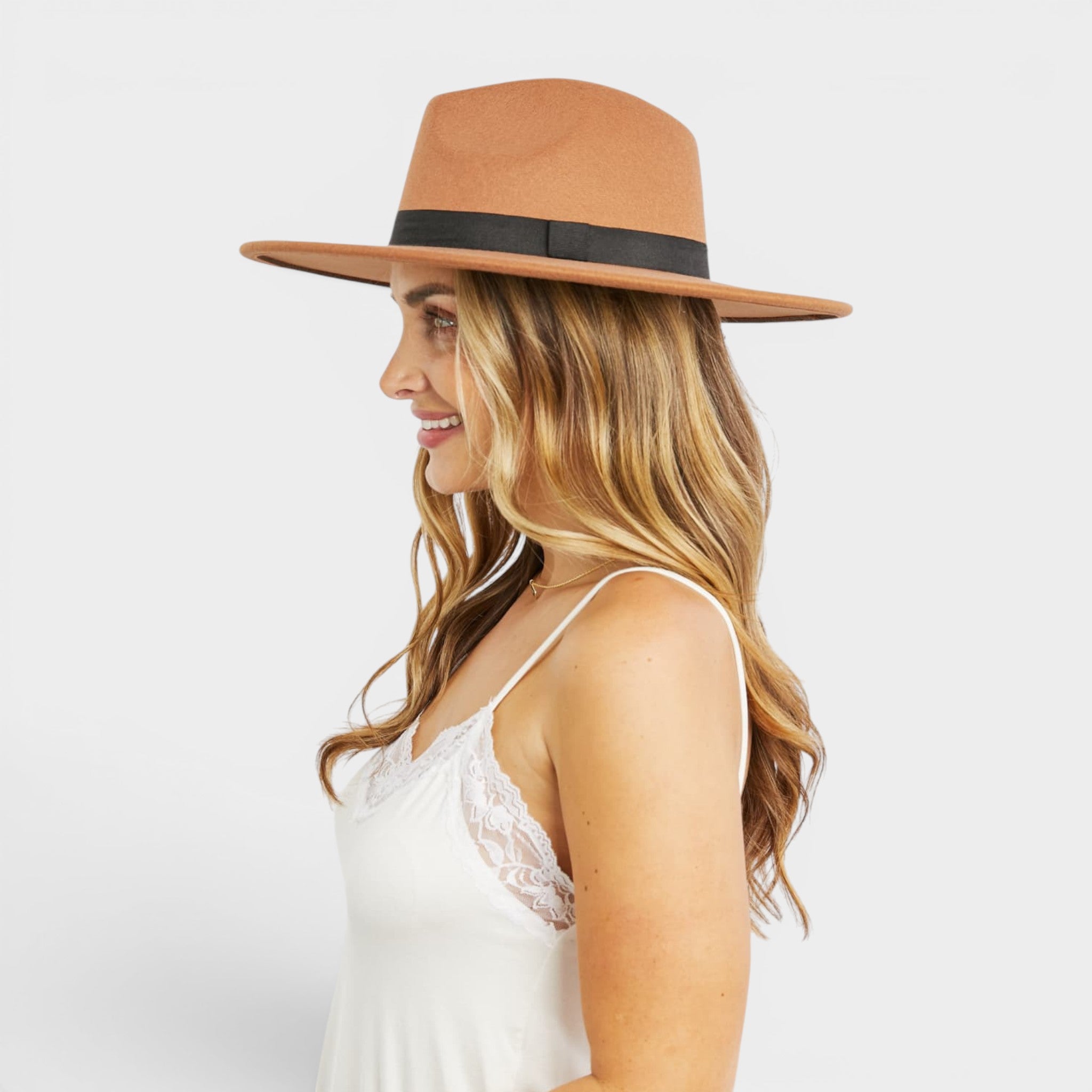 Woman wearing a brown hat with a black band on a white background