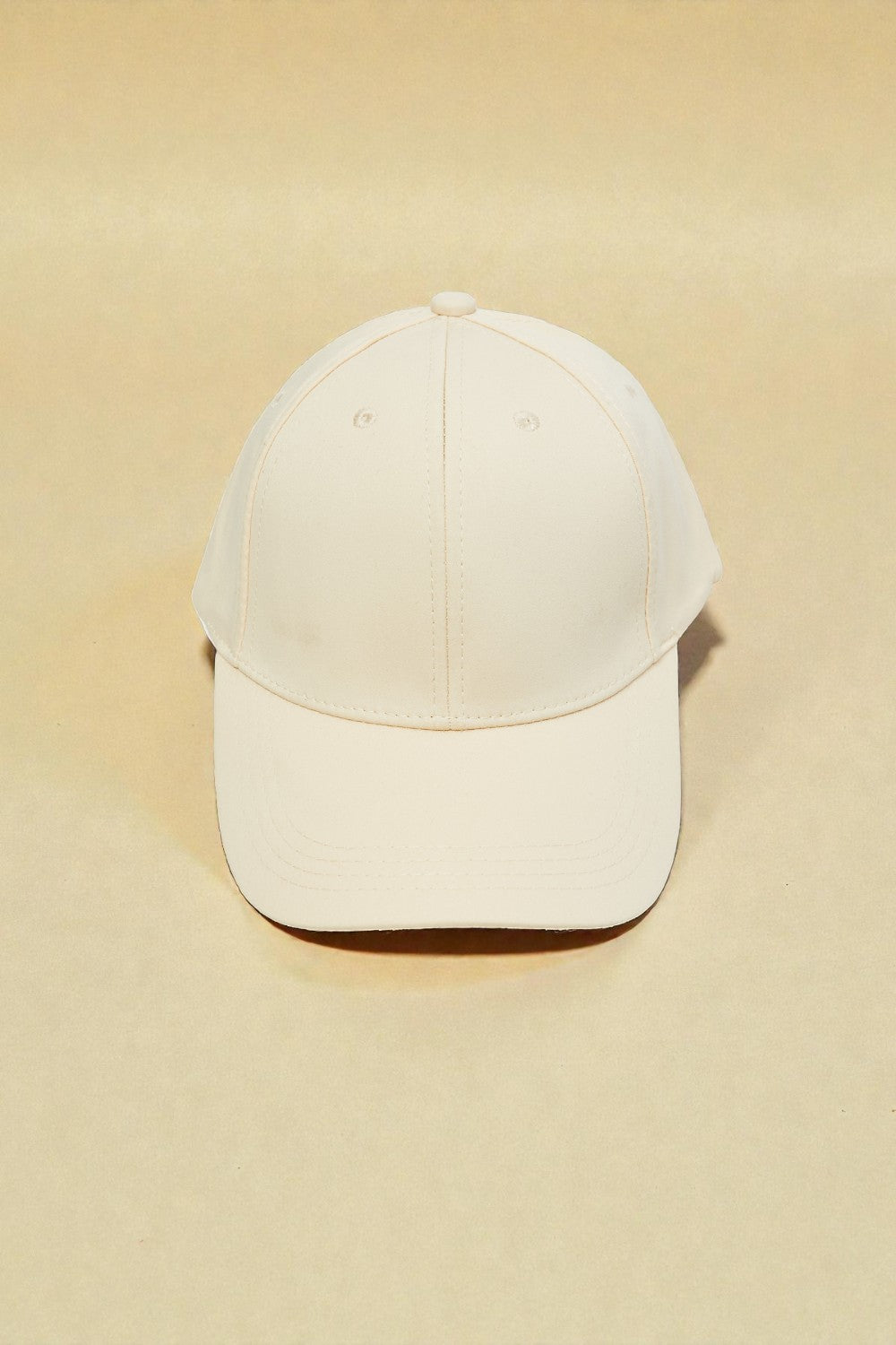 Beige baseball cap on a beige background